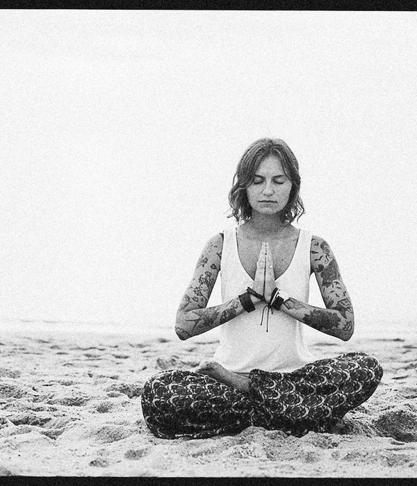 Person sitting peacefully in a meditation pose, surrounded by nature.